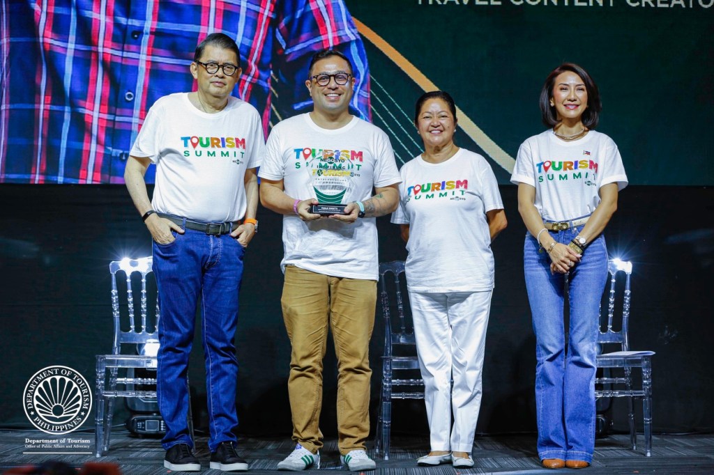 Paolo Rigotti receiving a Travel Content Creator award at the 2024 Tourism Summit from First Lady Liza Marcos, DOT Secretary Christina Frasco, and GoNegosyo founder Joey Concepcion.