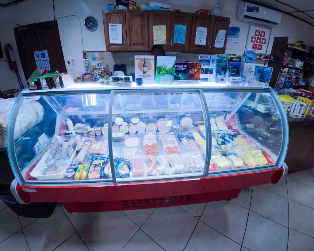 View of the well-stocked deli counter at TipTop, highlighting the variety of fresh products available for local residents.