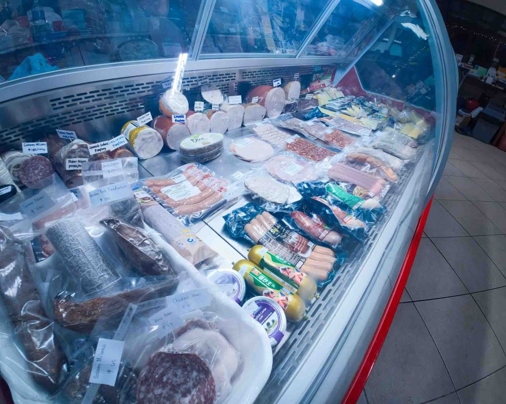 Close-up of the cold cut and sausage selection at TipTop Delishop, including house-made Swiss-style specialties.