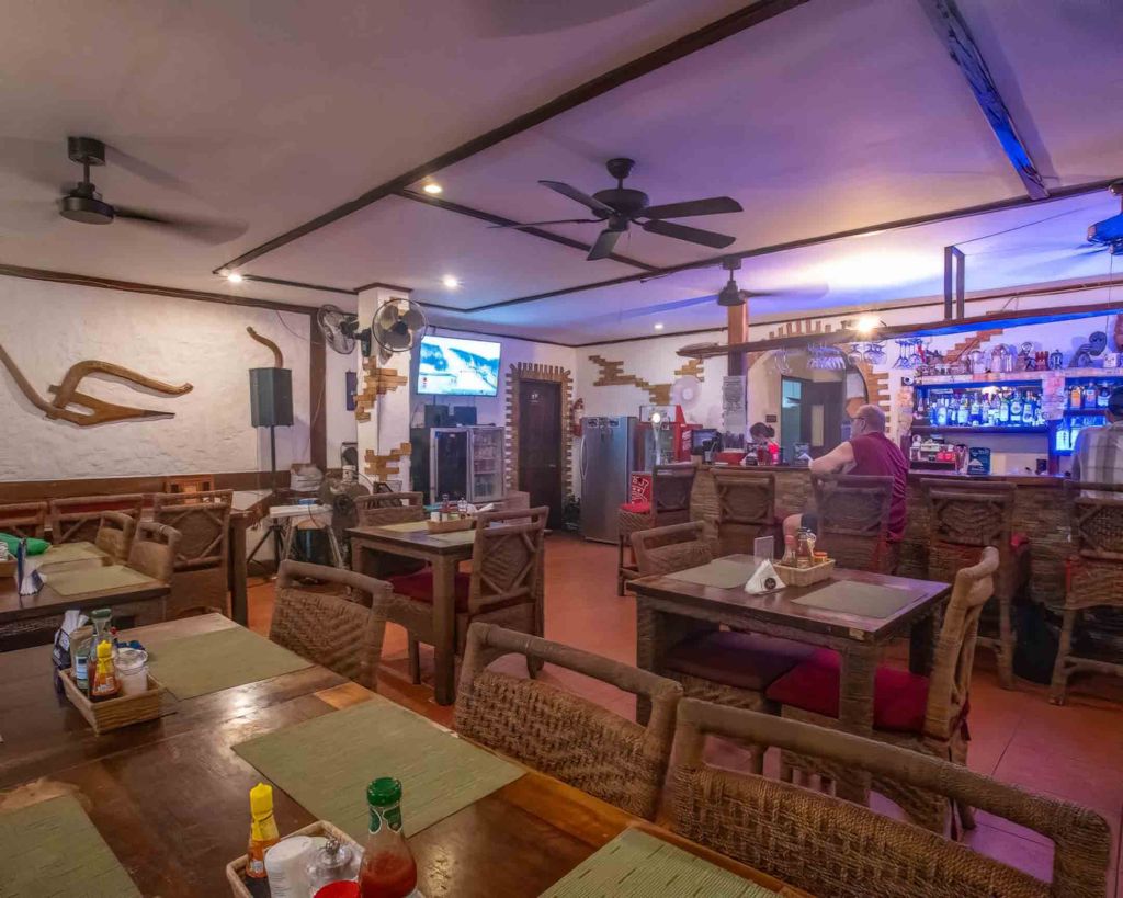 Cozy indoor dining area of TipTop Resto featuring traditional wooden furniture and a warm, casual atmosphere.
