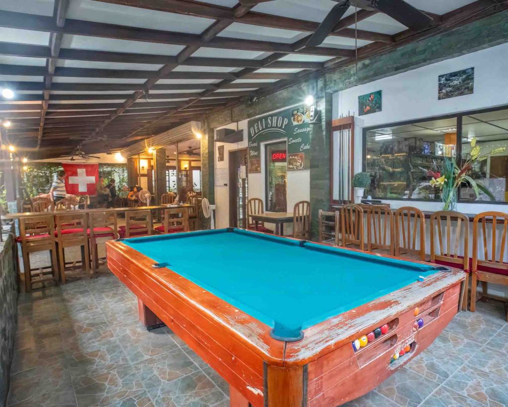 Leisure area at TipTop Panglao with a billiards table and Swiss flag decor, popular for community gatherings.